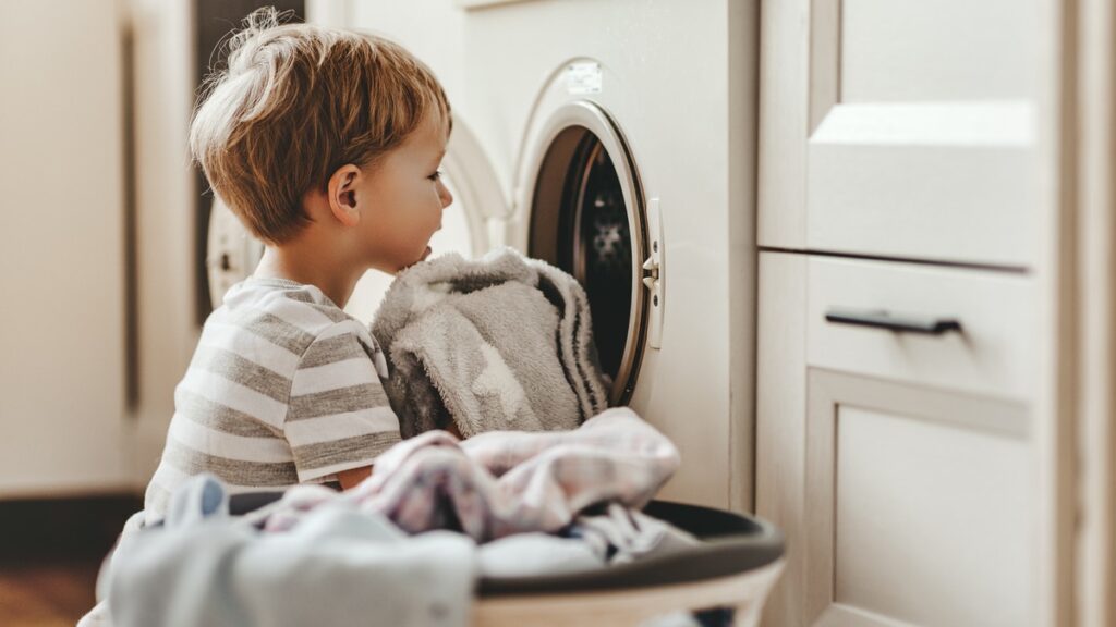 divisione delle faccende domestiche bambino davanti a lavatrice