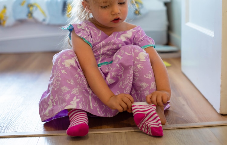 bambina piccola si infila i calzini da sola